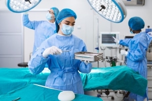 Surgical Technologist looking at equipment in the OR